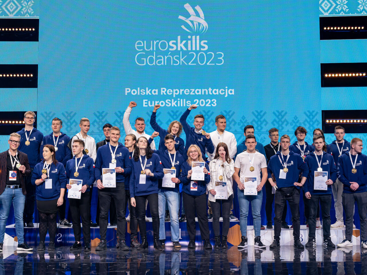Competitors celebrate on stage at SkillsPoland 2022, which took place in Gdańsk from 23-25 November 2022.
