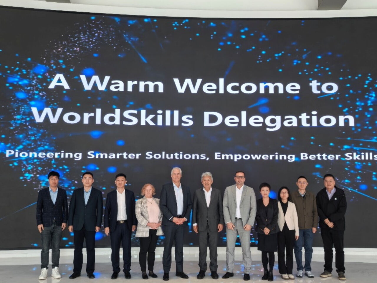 Representatives from Neusoft and WorldSkills International standing on stage.
