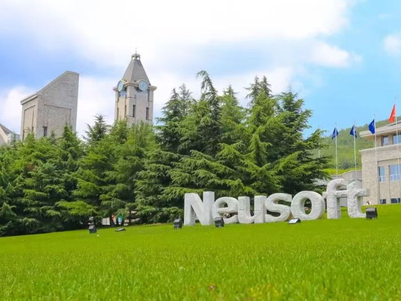 A large Neusoft logo on a grassy hill with towers in the background.&nbsp;
